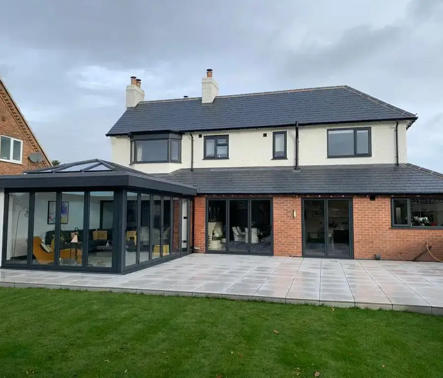 Rendered house with a glazed garden room extension and paved patio