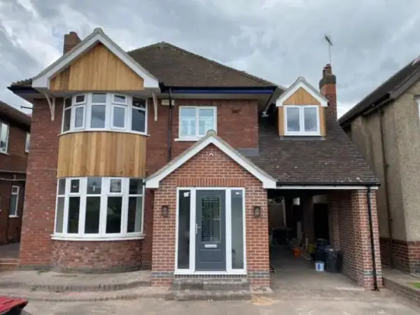 Bay-fronted house with a timber-clad bay and newly built brick porch