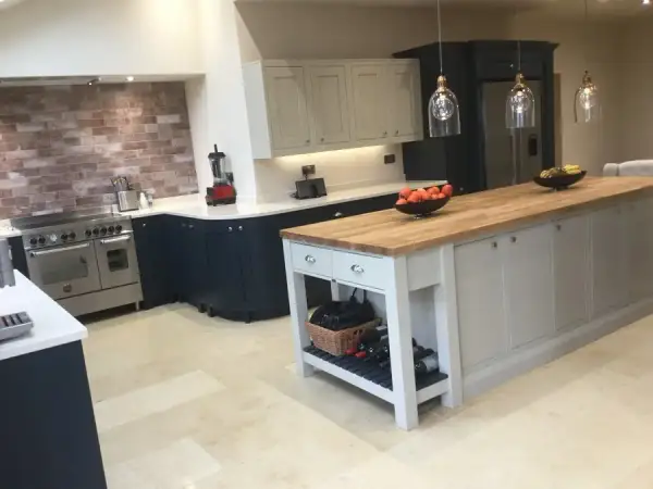 Kitchen with navy units, a freestanding island, range cooker and brick splashback